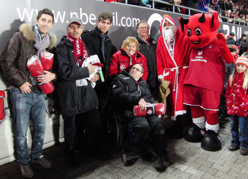 Auch Fairplay-Mitglied Georg wurde beschenkt (Bildmitte, im Rollstuhl): Von links Sascha Kotysch, Rolf Conrad (Fairplay), Kevin Trapp, Helga Huber (Fairplay), Otto Roth (Fairplay) sowie der Nikolaus in Begleitung von „Betzi“.