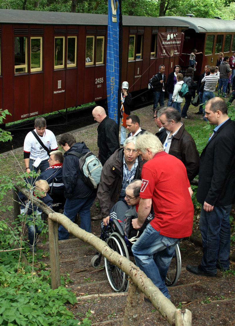 Alle halfen mit, die Rollifahrer über die Holztreppen hoch zu transportieren.