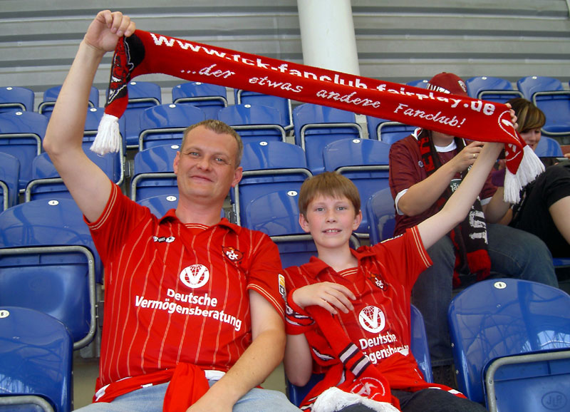 Vater und Sohn (Rainer mit Dominik Schmidt) zeigen in der „Veltins-Arena“ Flagge.