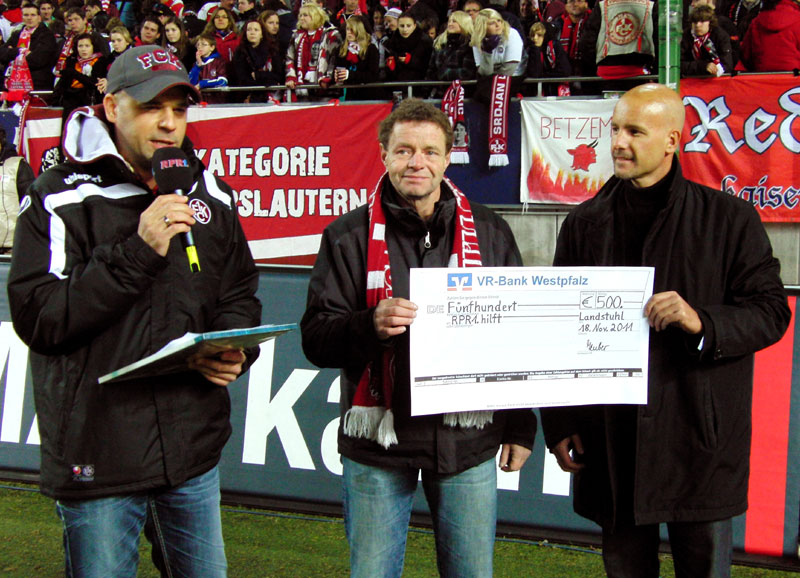 Scheckübergabe mit RPR1.Moderator Holger Schröder, Fairplay-Mitglied Günter Lotz und RPR1.-Key-Account Manager Steffen Haag (v.l.n.r.) im “Fritz-Walter-Stadion” vor der Westkurve. Ein Wadenbeinbruch verhinderte leider die Teilnahme von Günters Begleiterin.