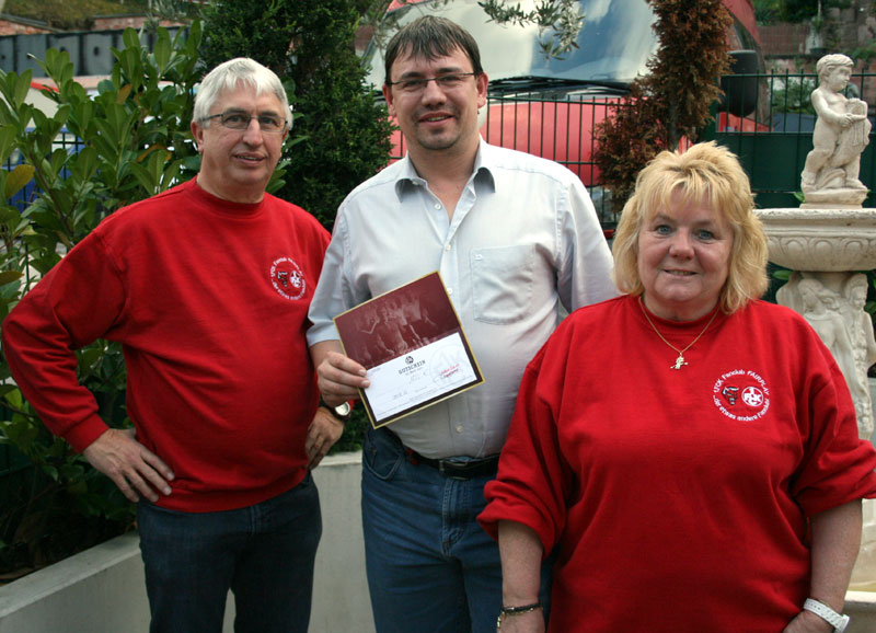  Michael Müller (Bildmitte) nahm im Namen aller drei Geehrten das Präsent für 10-jährige Fanclub-Treue entgegen (Foto: Bettina Huber).