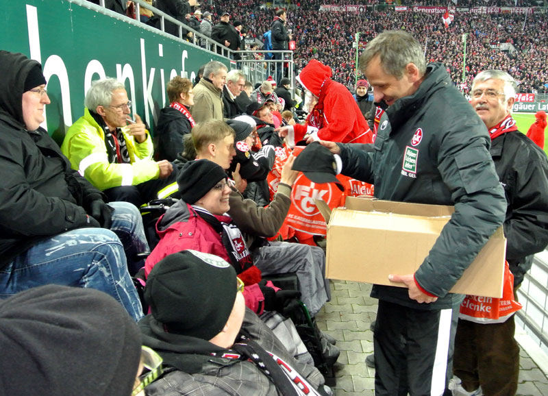  1. FCK-Team-Manager Roger Lutz beim Verteilen der Caps an die Rollstuhlfahrer im „Fritz-Walter-Stadion“.