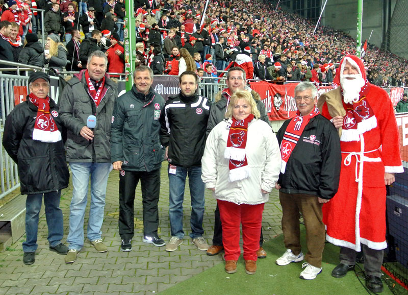  Die aktiv Beteiligten der „Weihnachts-Geschenk-Aktion“ kurz vor dem Start ihres Rundgangs zu den Rollstuhlfahrern im „Fritz-Walter-Stadion“: Rolf Conrad (Fairplay), Stadionsprecher Horst Schömbs, 1. FCK-Team-Manager Roger Lutz, 1. FCK Fanbetreuer Christoph Schneller, 1. FCK Behindertenbeauftragter Nino Gagliano, Helga Huber (Fairplay), Klaus Weckmüller (Fairplay) und der Nikolaus (v.l.n.r.). Auf dem Foto fehlt Christa Conrad (Fairplay).